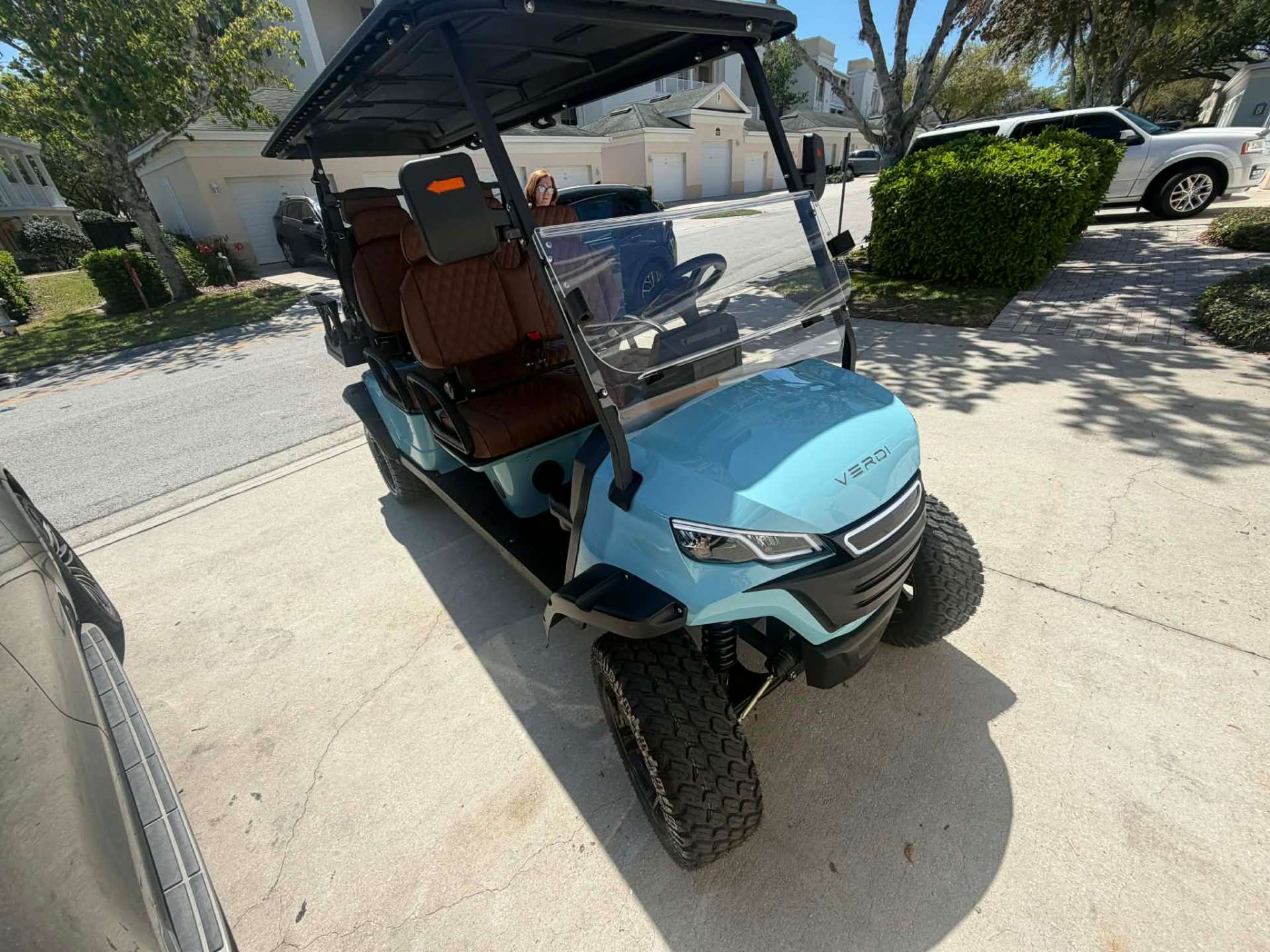 Teal Verdi luxury golf cart parked in a Champions Gate community driveway